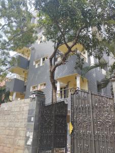 a house with a black gate and a tree at A.R Residency in Chennai