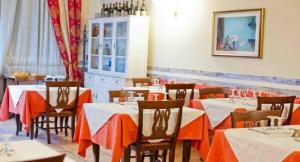 un comedor con mesas y sillas con mantel naranja en Villa Lia Depandance Hotel Sicilia, en Milán