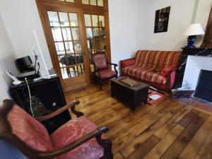 a living room with two chairs and a couch at Maison de bourg dans le Cantal in Champagnac