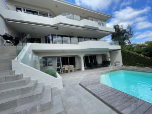 a house with a swimming pool in front of it at Holiday Villa with stunning views near beach. in Plettenberg Bay