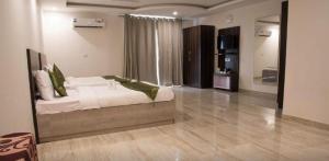 Hotel Lakshmi Palace في نيودلهي: غرفة نوم كبيرة مع سرير ومرآة كبيرة