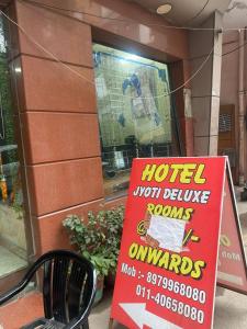 un cartello di fronte a un negozio con un cartello di hoteloituceolisolis in di Hotel Jyoti Deluxe a Nuova Delhi