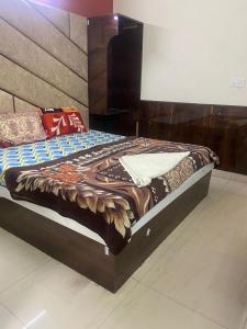 una camera con un letto con una grande testiera in legno di Hotel Jyoti Deluxe a Nuova Delhi