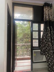 una finestra aperta con vista su un balcone di Hotel Jyoti Deluxe a Nuova Delhi