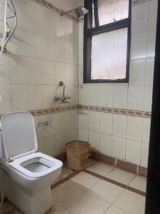 bagno con servizi igienici e finestra. di Hotel Jyoti Deluxe a Nuova Delhi
