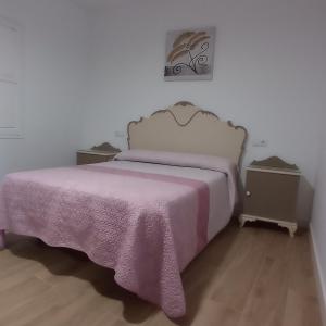 a bedroom with a bed with a pink blanket at Casa Chacha Tere in Montoro
