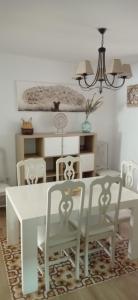 a dining room with a white table and chairs at Casa Chacha Tere in Montoro