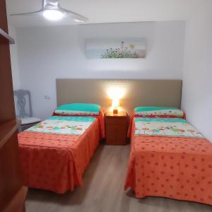 a bedroom with two beds and a lamp in it at Casa Chacha Tere in Montoro