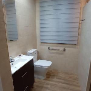 a bathroom with a white toilet and a sink at Casa Chacha Tere in Montoro