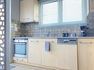 雅典的住宿－TINY LITTLE STUDIO，一个带木制橱柜和水槽的厨房