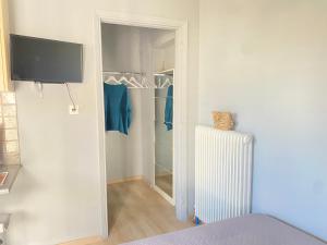 um quarto com um closet com um radiador em TINY LITTLE STUDIO em Atenas