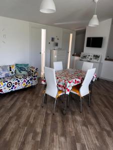 ein Wohnzimmer mit einem Tisch, Stühlen und einem Bett in der Unterkunft Splendido appartamento a due passi dal mare in Termoli