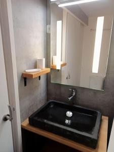 La salle de bains est pourvue d'un lavabo noir et d'un miroir. dans l'établissement Val Thorens Studio 2 personnes et balcon Plein Sud, à Val Thorens