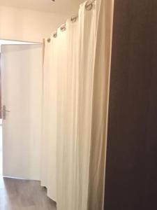 - un rideau de douche blanc dans une chambre avec une porte dans l'établissement Val Thorens Studio 2 personnes et balcon Plein Sud, à Val Thorens