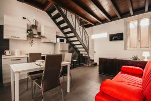 Il comprend une cuisine et un salon avec un canapé rouge et une table. dans l'établissement Bigattera lofts - Affitti Brevi Italia, à Varèse