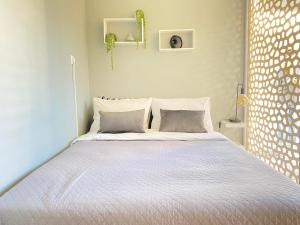 - une chambre blanche avec un lit et deux oreillers dans l'établissement TINY LITTLE STUDIO, à Athènes