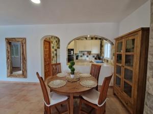 Il comprend une cuisine et une salle à manger avec une table et des chaises en bois. dans l'établissement Tower house, à Cómpeta