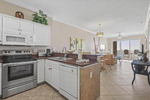 a kitchen with white appliances and a dining room at Island Royale P102 in Gulf Shores