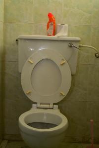 un bagno con servizi igienici bianchi e spazzola rossa di Dennis Prince pm comfy home a Nairobi
