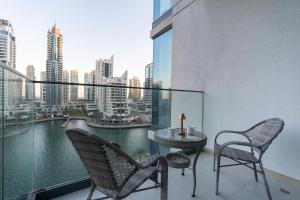 杜拜的住宿－ArbabHomes Lavish 2BR Dubai Marina View-LIV Residences，大楼内的阳台配有两把椅子和一张桌子