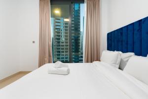 a bedroom with a large white bed with a window at ArbabHomes Lavish 2BR Dubai Marina View-LIV Residences in Dubai