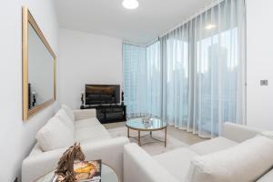 a living room with white furniture and large windows at ArbabHomes Lavish 2BR Dubai Marina View-LIV Residences in Dubai