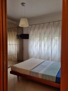 a bedroom with a bed and a window with curtains at Delizioso e silenzioso appartamento a Roma in Rome