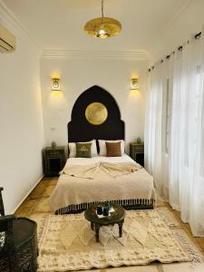 1 dormitorio con 1 cama grande y 1 mesa en Riad Bjoujna, en Marrakech