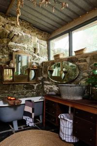 a stone walled bathroom with a sink and mirrors at Crab Lane Studios in Carlow
