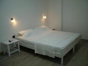 1 dormitorio con cama blanca y mesa auxiliar en Villa Felice, en Porto Cesareo