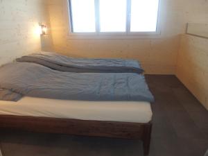 Bett in einem Zimmer mit Fenster in der Unterkunft Bätzenboden Stöckli 1375A in Wengen