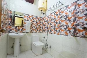 a bathroom with a toilet and a sink at Trimrooms Trinity Katra in Katra
