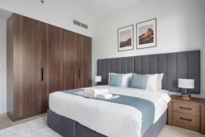 a bedroom with a large bed with a wooden headboard at StoneTree - Luxury 1BR - Best Location for Tourist in Dubai