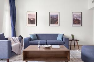 a living room with a blue couch and a coffee table at StoneTree - Luxury 1BR - Best Location for Tourist in Dubai