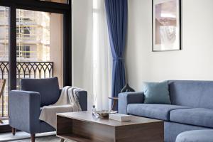 a living room with a couch and two chairs and a coffee table at StoneTree - Luxury 1BR - Best Location for Tourist in Dubai