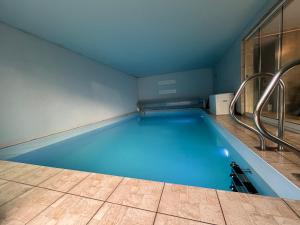 a large blue swimming pool in a room at Villa avec piscine intérieure in Holtzheim