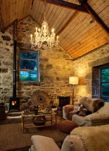 a living room with a chandelier and a stone wall at Crab Lane Studios in Carlow