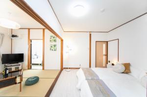 a bedroom with a large bed and a tv at 菰野ガーデンリゾート 