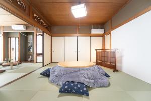 um quarto com uma mesa e almofadas no chão em 菰野ガーデンリゾート 