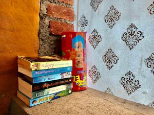 a stack of books sitting on a ledge next to a wall at H2H Bir l Nature Camps in Bīr