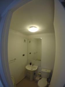 a bathroom with a sink and a toilet and a mirror at Apartamento la serena in Coquimbo
