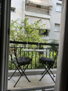 uma varanda com duas cadeiras e uma mesa em Agapi’s apartment em Tessalônica