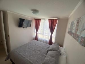 a small bedroom with a bed and a window at Apartamento la serena in Coquimbo