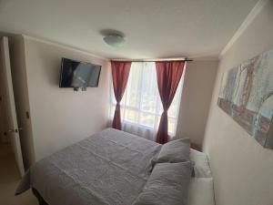 Habitación pequeña con cama y ventana en Apartamento la serena, en Coquimbo