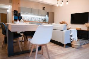 una cucina e un soggiorno con tavolo e divano di Chez Rose - Plein Centre Historique a Langres