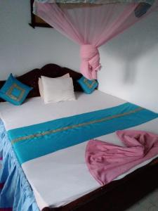 a bed in a room with a canopy and a bedskirtspectspects at Rock Cascade tourist home in Polonnaruwa