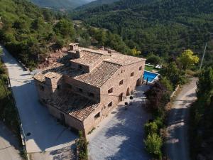 an aerial view of an old building with mountains in the background at Vila Caelus masía boutique in Rubio