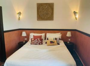 a bedroom with a white bed with pillows on it at Riad Bjoujna in Marrakesh