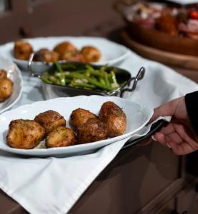 a person holding a plate of food with potatoes and broccoli at R.HOTEL in Chernivtsi