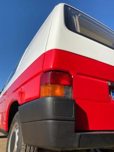 a red and white van parked in a parking lot at Camper Van in Villacarlos